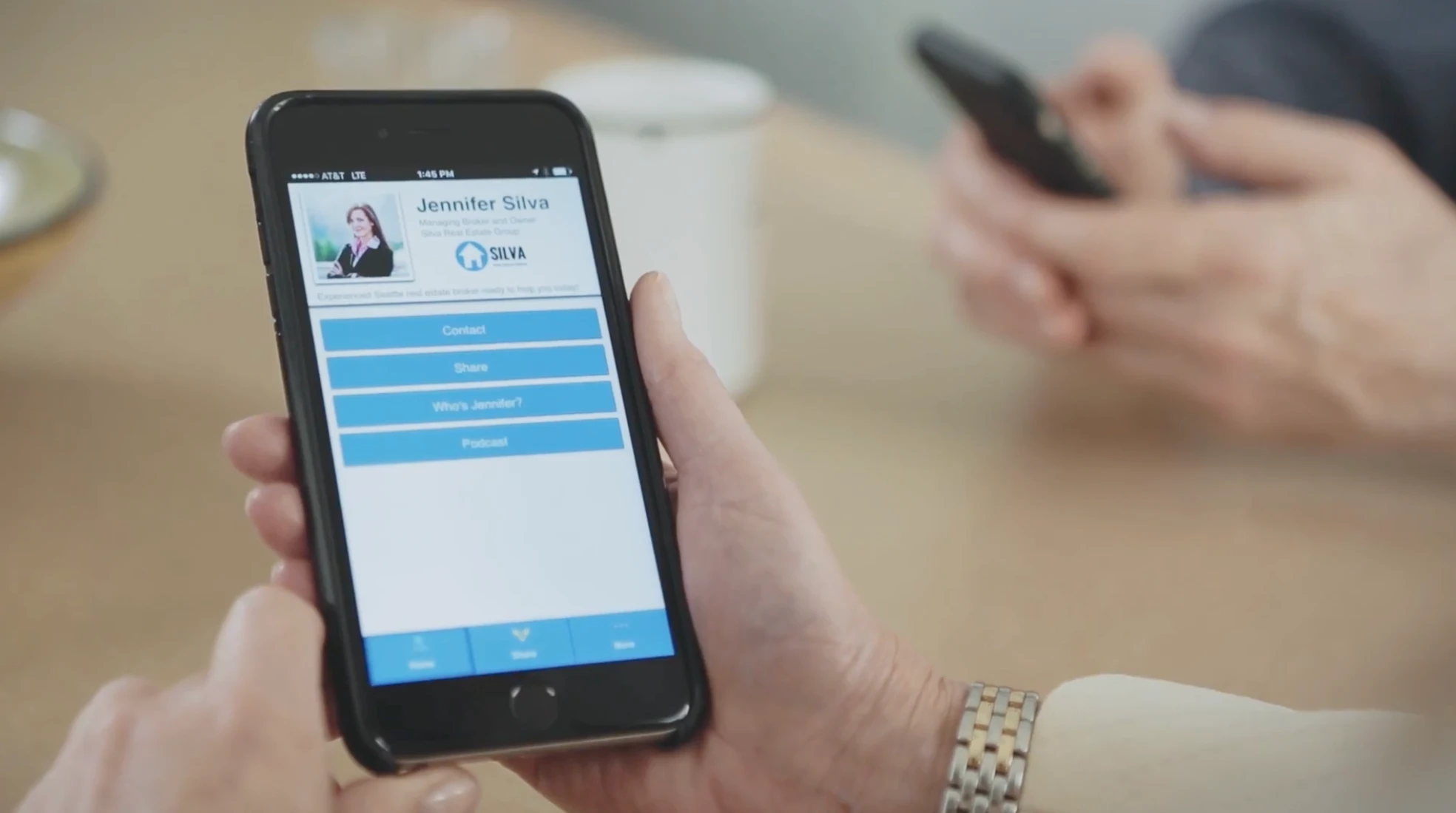 The product on a phone — a professional's shareable profile with Contact, Share, and more.